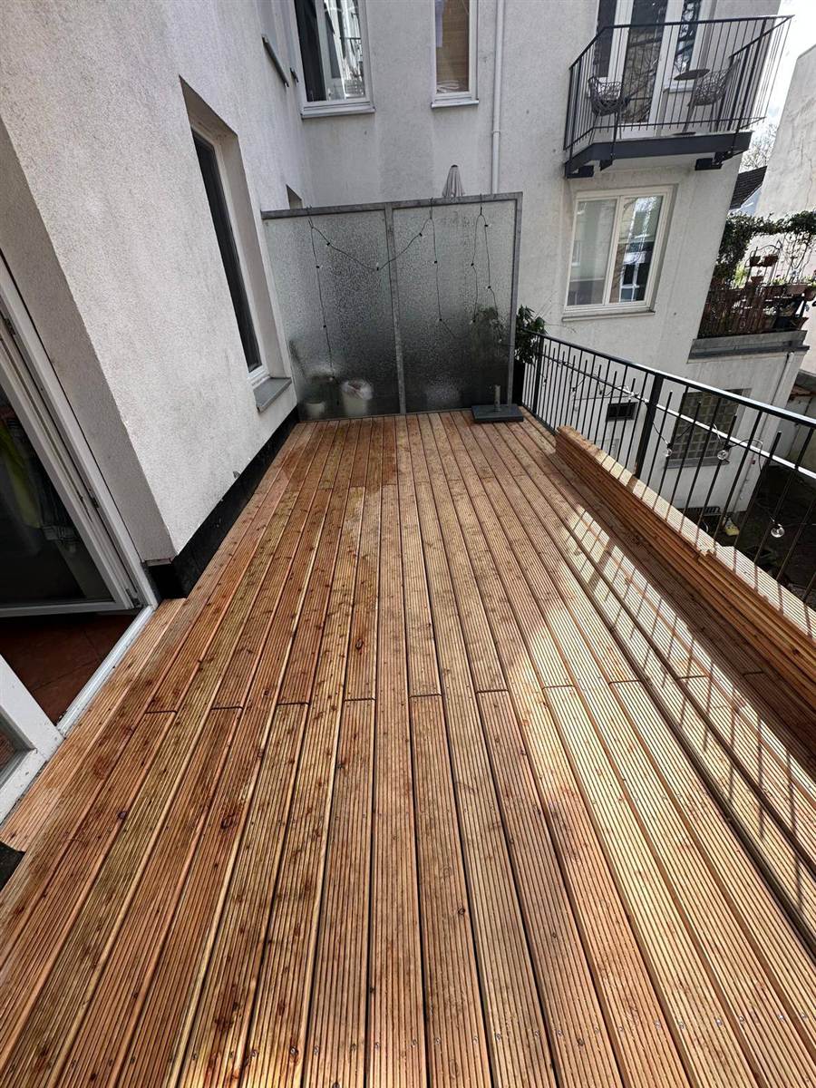 Balkon mit Holzdielen und eingebauter Sitzbank