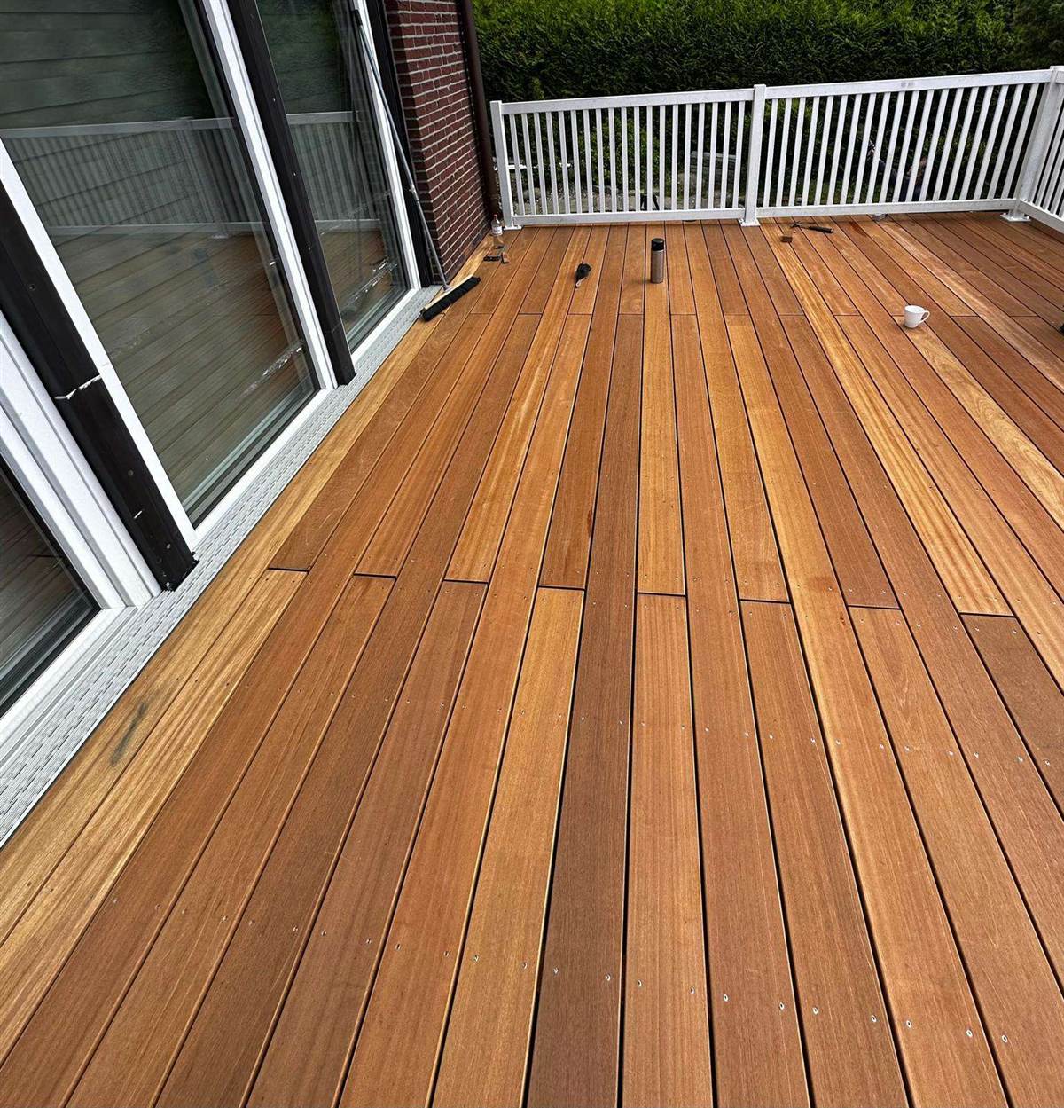 Fertig verlegte Terrassendielen vor bodentiefen Fenstern